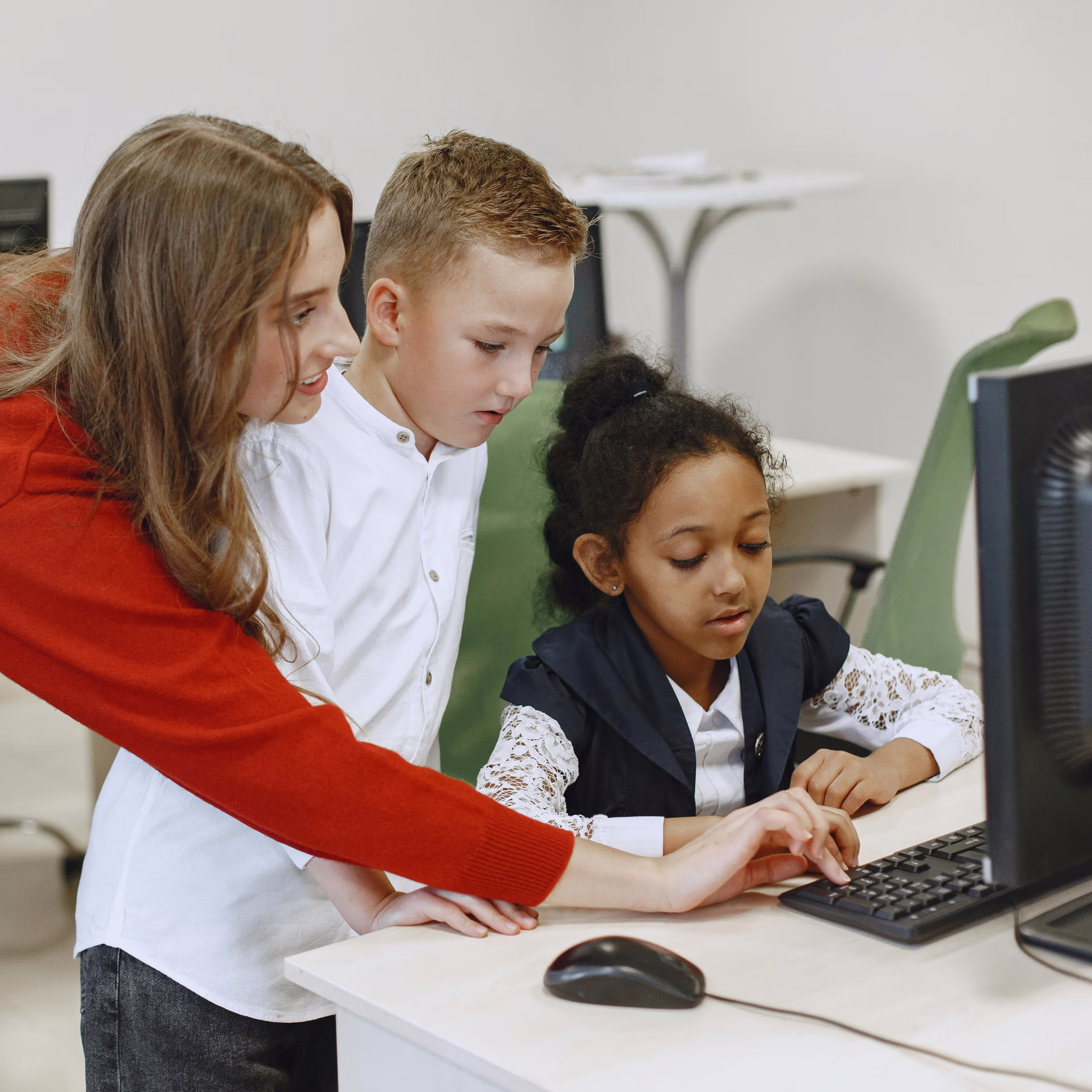 Teacher helping students at a computer
